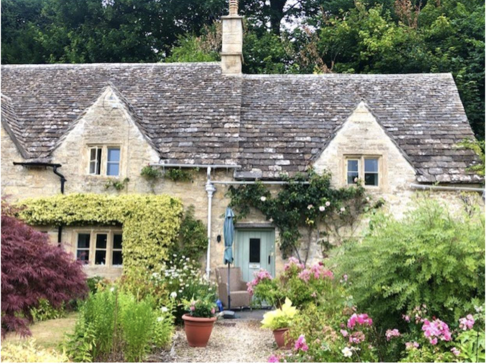 A cottage with a green garden in the Cotswolds, England